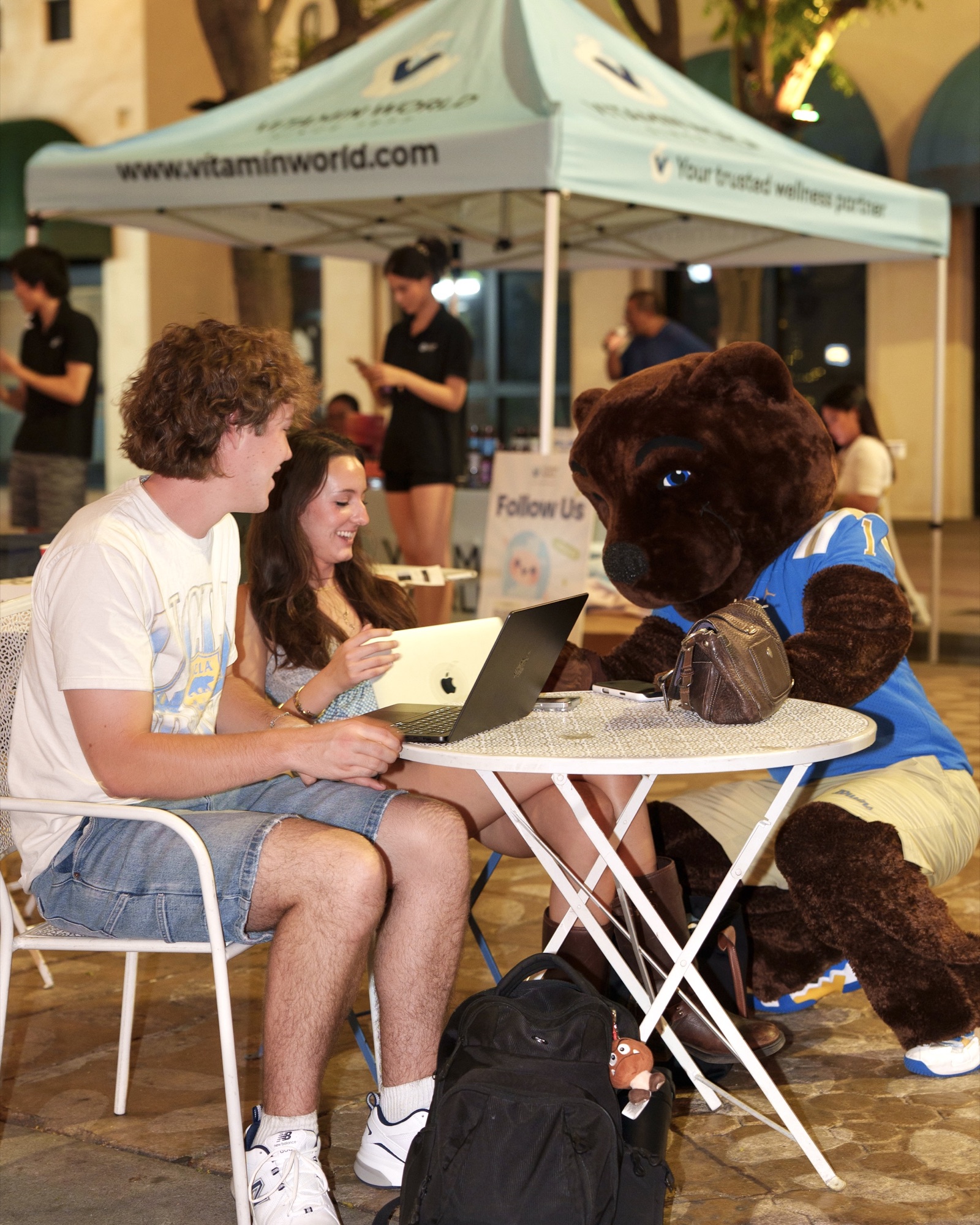 Guests and the bear mascot sitting together at a table